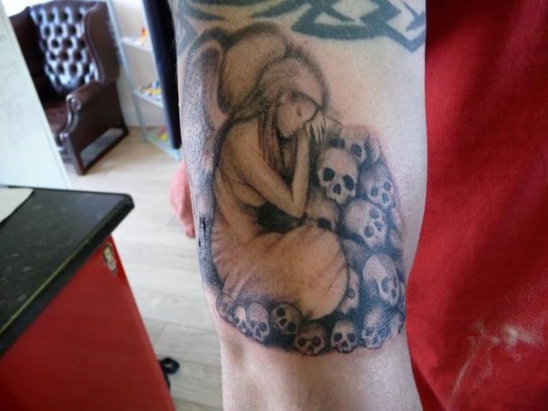 Grieving angel and skull tattoo on arm
