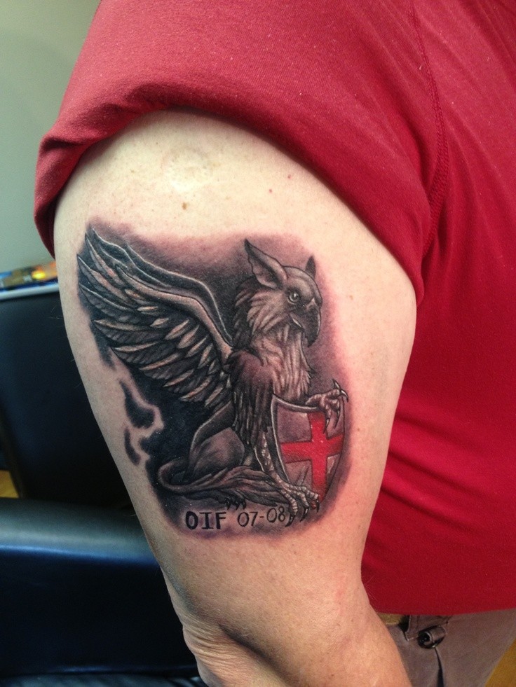 Tatuaje en el brazo, grifo hermoso gris con escudo