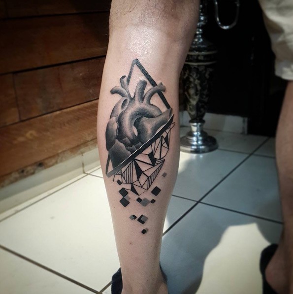 Half realistic half geometrical style leg tattoo of human heart with figures