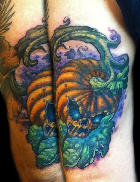 Halloween style multicolored demonic pumpkin tattoo on elbow