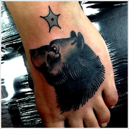 testa di orso nero con stella tatuaggio sul piede