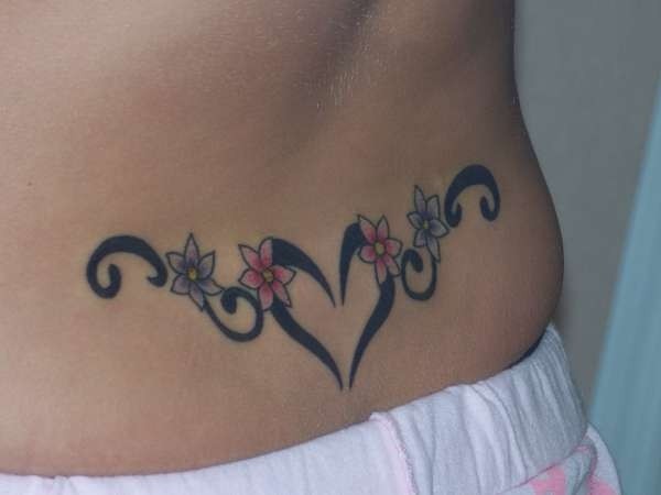 Tatuaje en la espalda baja, corazón de contornos gruesos y flores