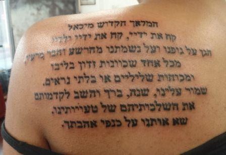 Hebrew scripture tattoo on shoulder blade