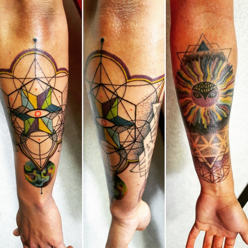 Hinduism style colored forearm tattoo of various ornaments and mystic sun
