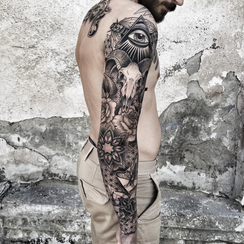 Hinduism themed black ink sleeve tattoo of various mystical ornaments and goat skull