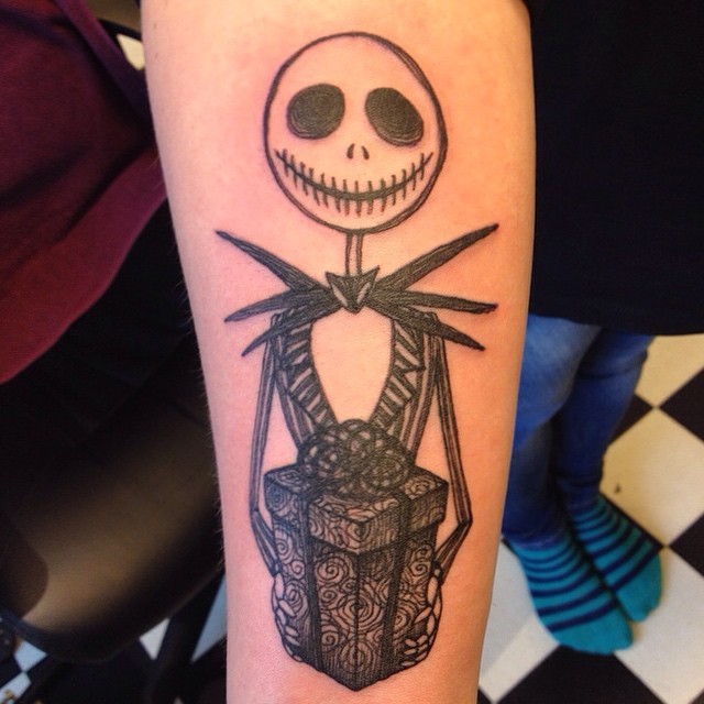 Home made black ink forearm tattoo of cute monster with present box