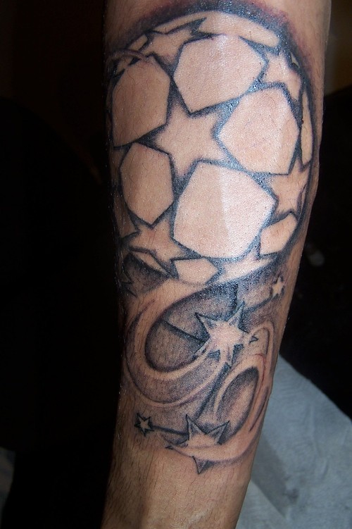 Homemade black and white football tattoo on arm with stars