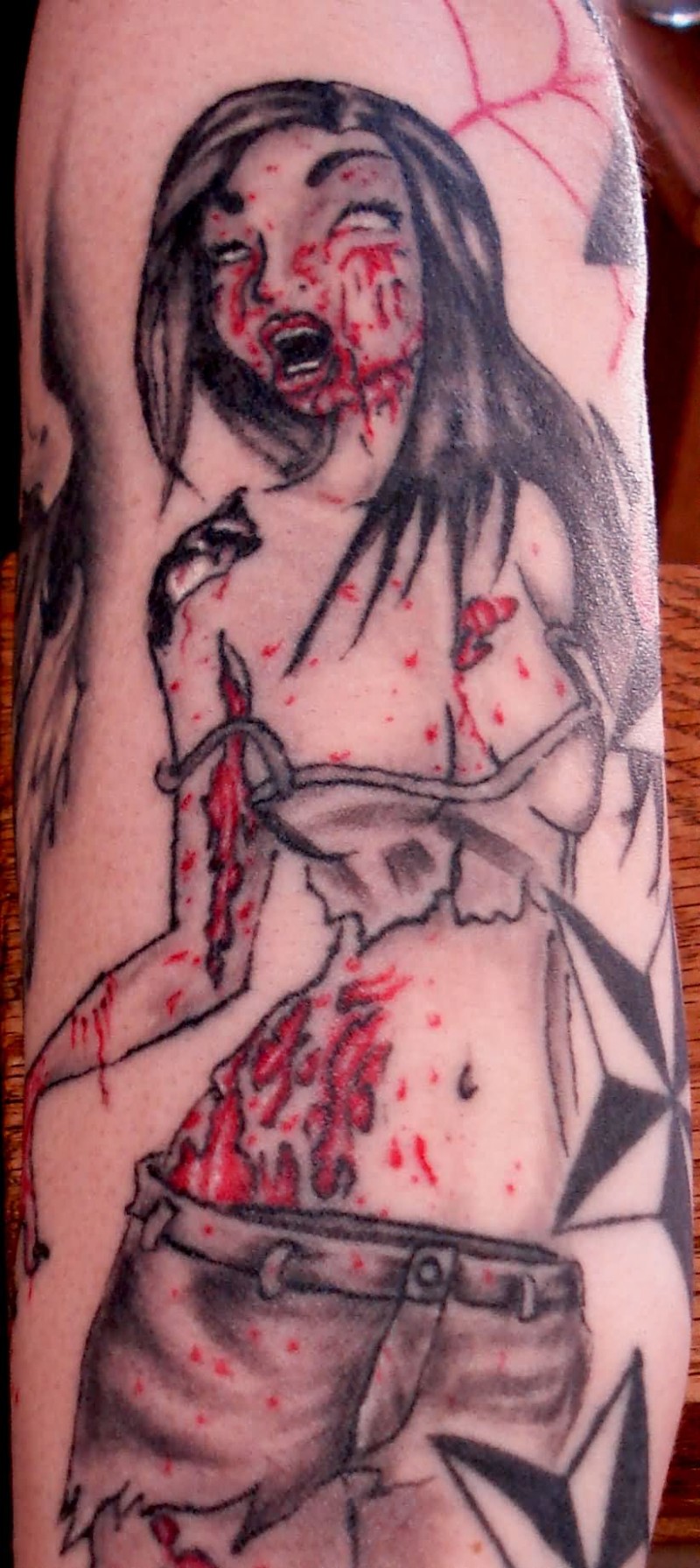 Homemade carelessly painted bloody woman tattoo on shoulder