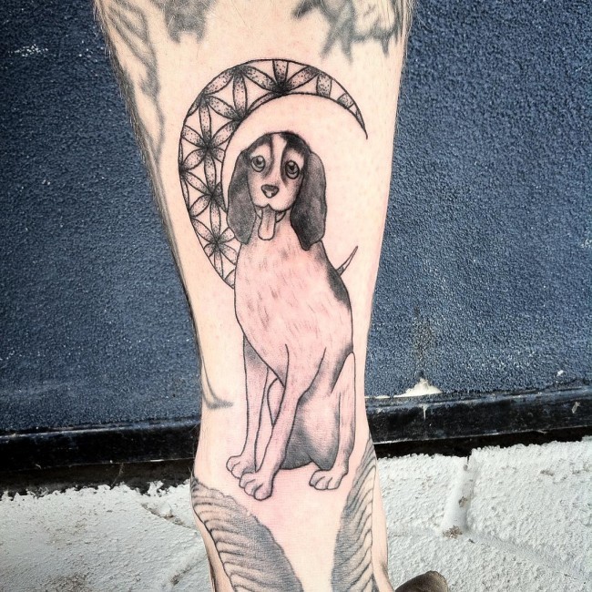 Homemade carelessly painted leg tattoo of funny dog and moon