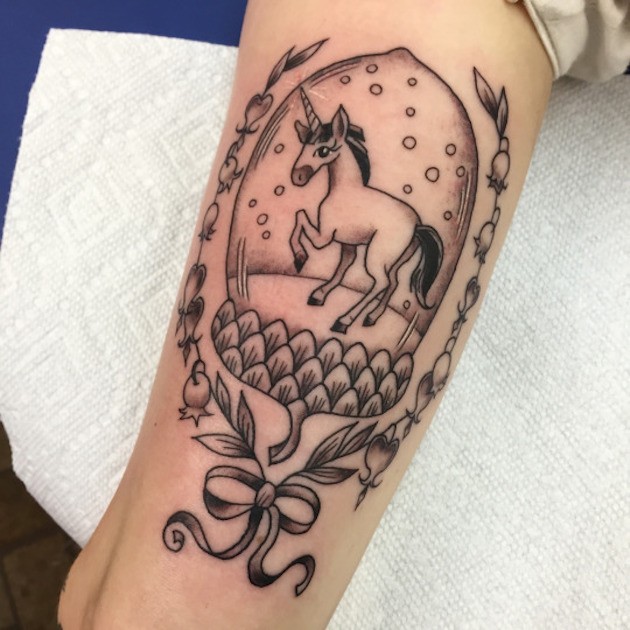 Tatuaje negro blanco de unicornio fantástico  en el brazo
