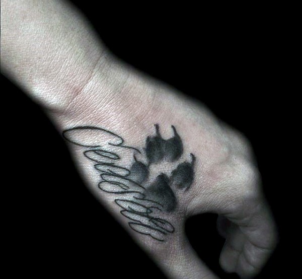 Homemade style black ink memorial hand tattoo fo animal paw print and lettering