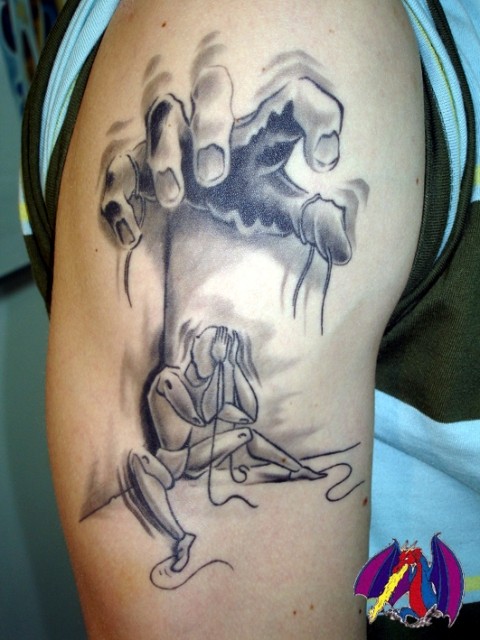 Homemade style black ink shoulder tattoo of human hand with puppet
