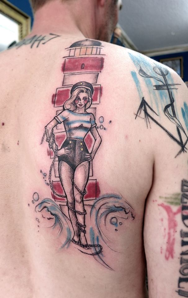 Homemade style colored back tattoo of lighthouse with sexy sailor woman