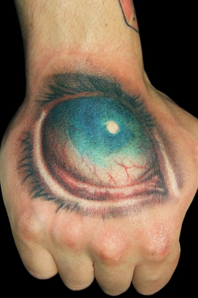 Horrifying painted big colored eye tattoo on hand