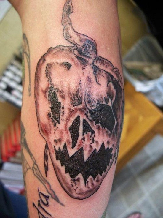 Horror cartoon like simple black and white evil pumpkin tattoo on arm