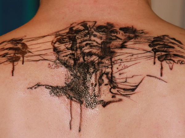 Horror style black ink back tattoo of monster face