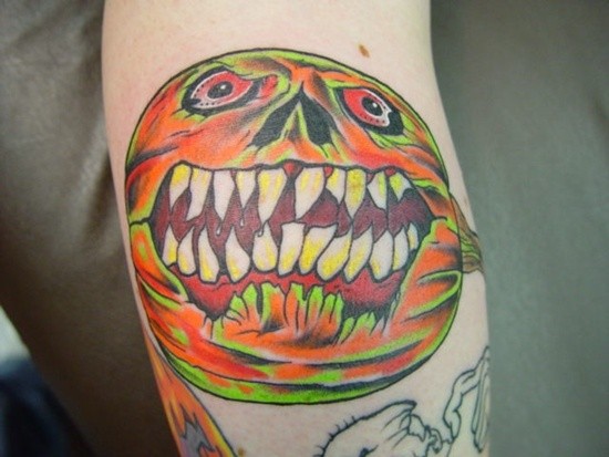 Horror style colored crazy evil pumpkin tattoo on arm