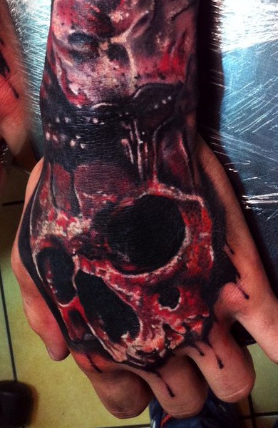 horror style colored hand tattoo of bloody human skull part