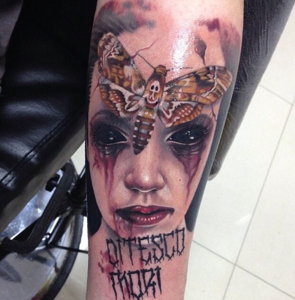 Horror style creepy looking arm tattoo of demon woman with butterfly