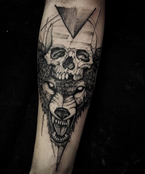 Horror style creepy looking forearm tattoo of wolf head with human skull