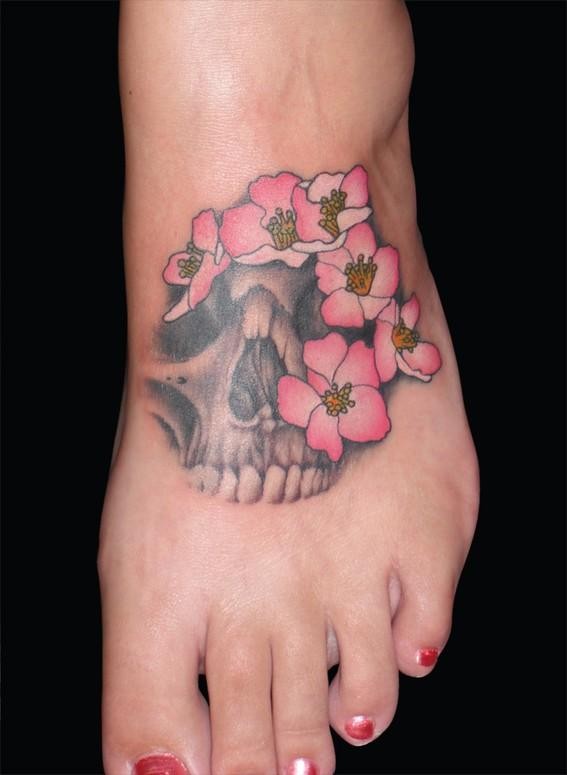 Human skull fragment with pale pink tender flowers foot in horror style
