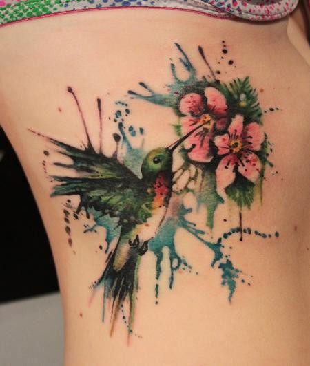 Tatuaje en el costado, colibrí y flor, manchas de pintura