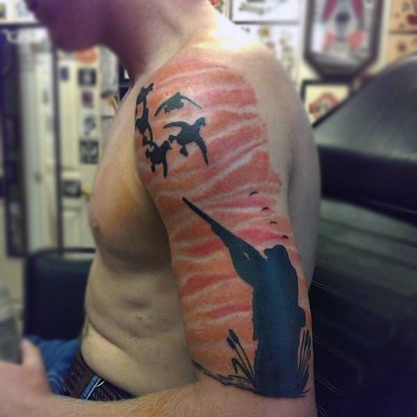 Hunting themed illustrative style colored shoulder tattoo of hunter with flying ducks