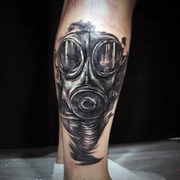 Illustrative style black ink leg tattoo of gas mask