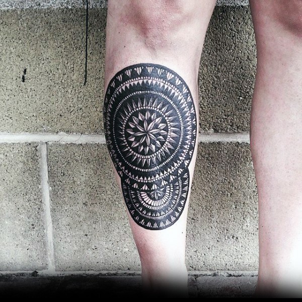 Illustrative style black ink leg tattoo of circle shaped ornament