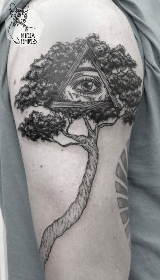 Illustrative style black ink shoulder tattoo of big tree with mysterious eye