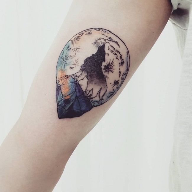 Illustrative style colored arm tattoo of wolf and night moon