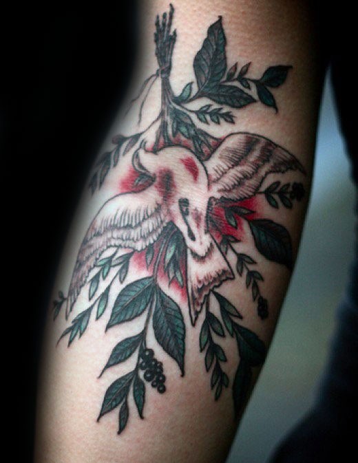Illustrative style colored arm tattoo of wounded bird and tree branch