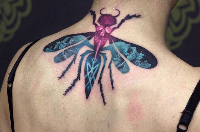 Illustrative style colored back tattoo of large insect stylized with skulls