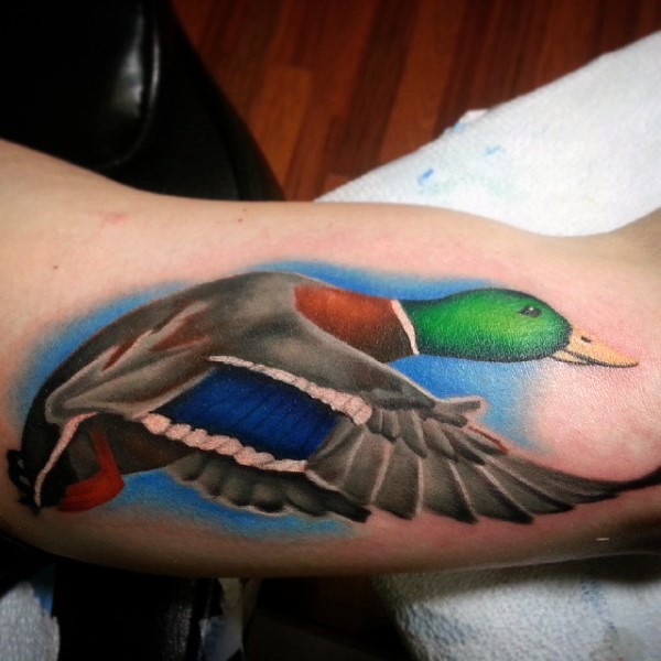 Illustrative style colored biceps tattoo of flying duck