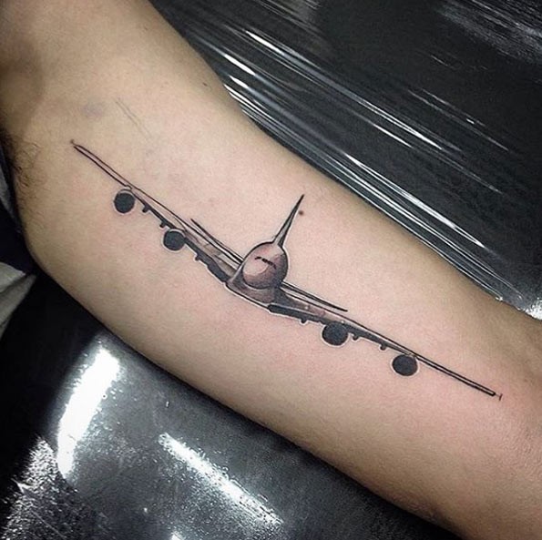 Illustrative style colored biceps tattoo of passenger plane