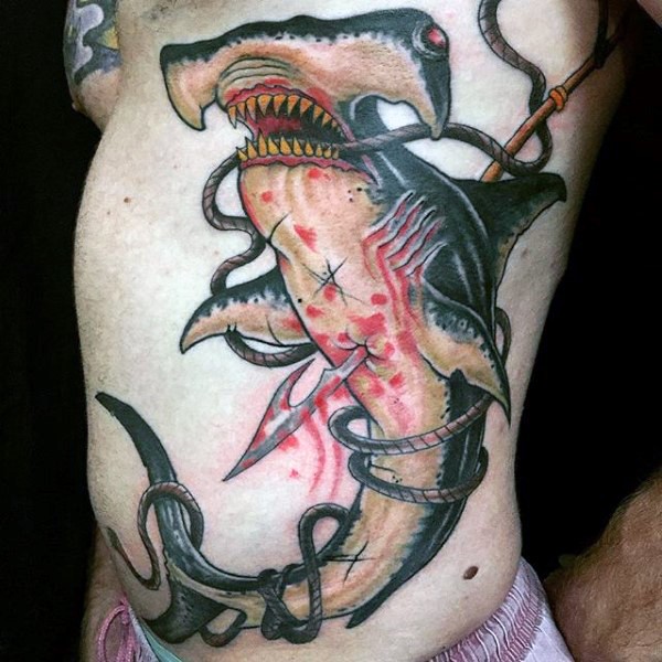 Illustrative style colored bloody harpooned hammerhead shark tattoo on side