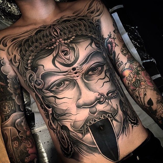 Illustrative style colored chest and belly tattoo of creepy face