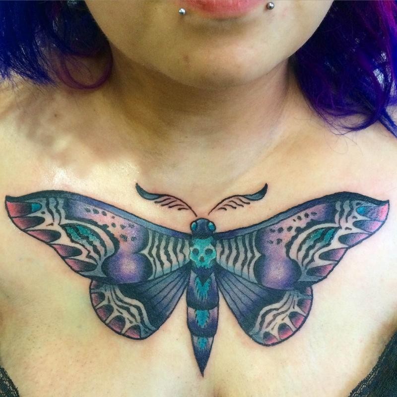 Illustrative style colored chest tattoo of big butterfly with human skull