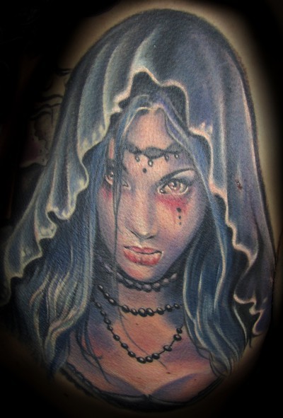 Illustrative style colored demonic woman in hood tattoo