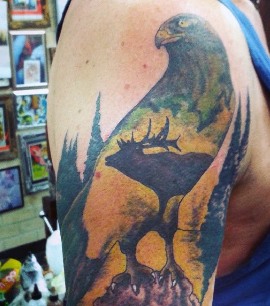 Illustrative style colored eagle tattoo on shoulder stylized with elk