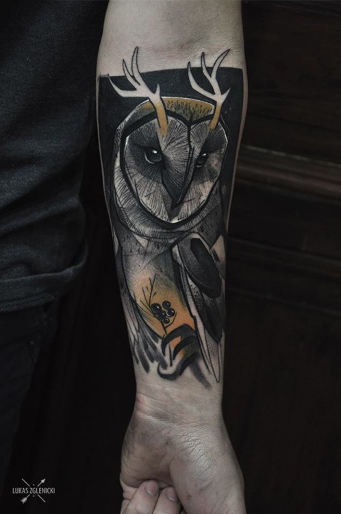 Illustrative style colored forearm tattoo of owl with horns