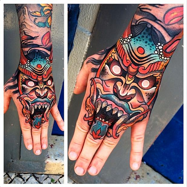 Illustrative style colored hand tattoo of demonic mask