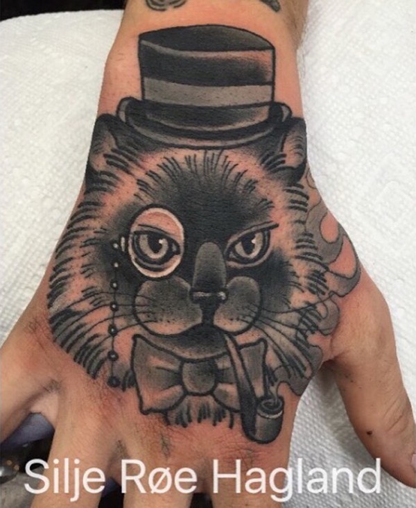 Illustrative style colored hand tattoo of cat with smoking pipe and hat