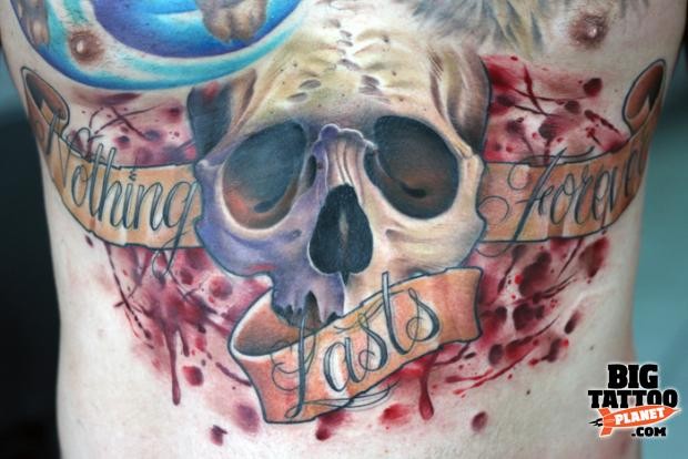 Illustrative style colored human skull tattoo on chest with lettering