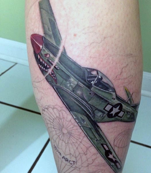 Illustrative style colored leg tattoo of WW2 fighter plane