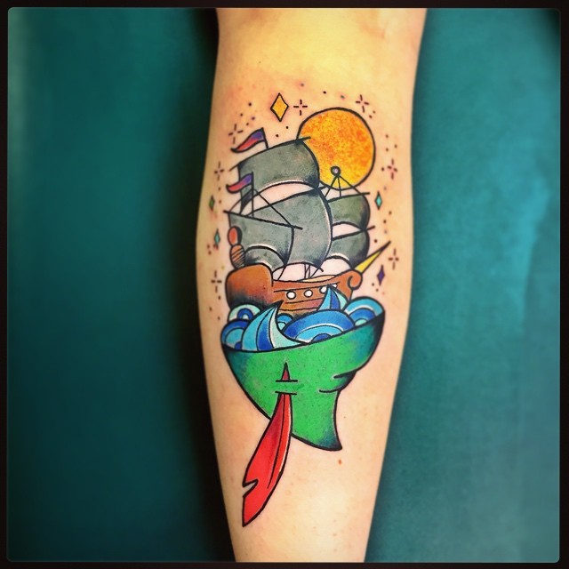 Illustrative style colored leg tattoo of Peter Pan hat and sailing ship