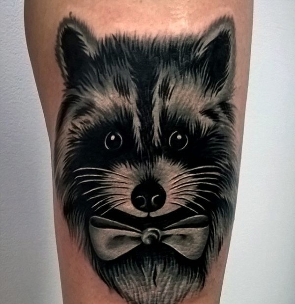Illustrative style colored leg tattoo of raccoon with bow