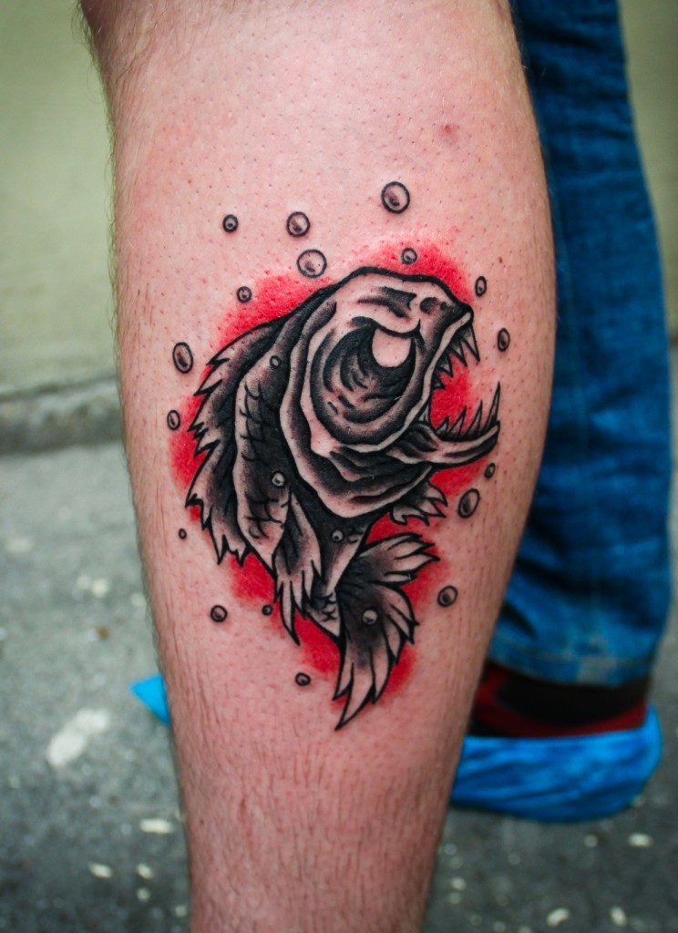 Illustrative style colored leg tattoo of evil fish