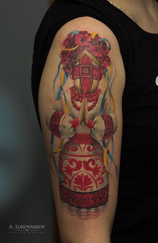 Illustrative style colored naive doll tattoo on shoulder