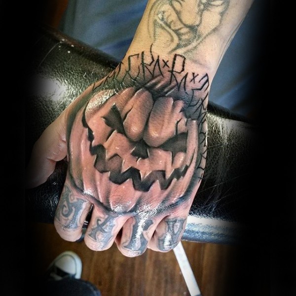 Illustrative style colored pumpkin tattoo on hand with lettering